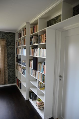 bokhylla med olika djup inbyggd runt dörröppning